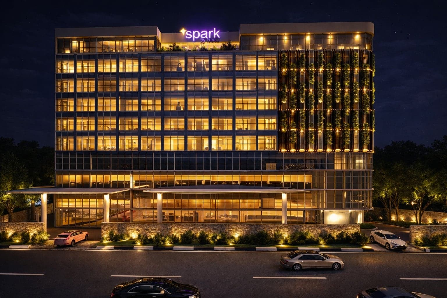 The Sulur Hotel at night — lit guest-room floors and a planted facade above the retail podium